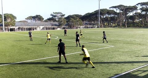 Soccer Teams Practicing Under Clear Sky on Verdant Field