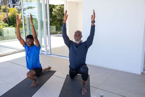 Men Practicing High-Lunge Yoga Pose Outdoors on Sunny Day