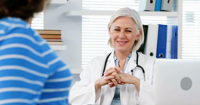 Senior female doctor talking with patient in modern office - Download Free Stock Images Pikwizard.com