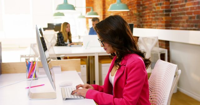 Woman in Pink Blazer Working at Computer in Modern Office - Download Free Stock Images Pikwizard.com