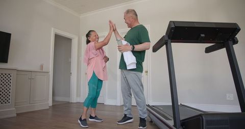Asian seniors enjoying fitness at home with friendly interaction