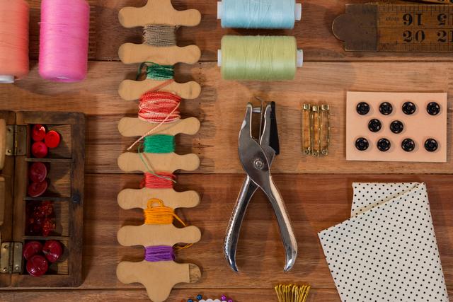 Perfect for illustrating sewing and crafting projects, this image showcases a variety of sewing tools and supplies neatly arranged on a wooden table. Ideal for use in blogs, tutorials, and advertisements related to sewing, DIY crafts, and needlework.