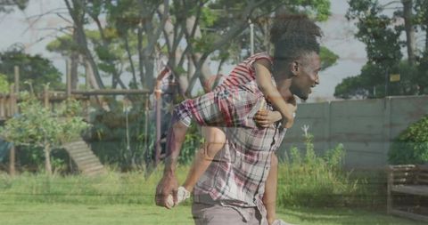 Father bonding with daughter in sunny backyard play