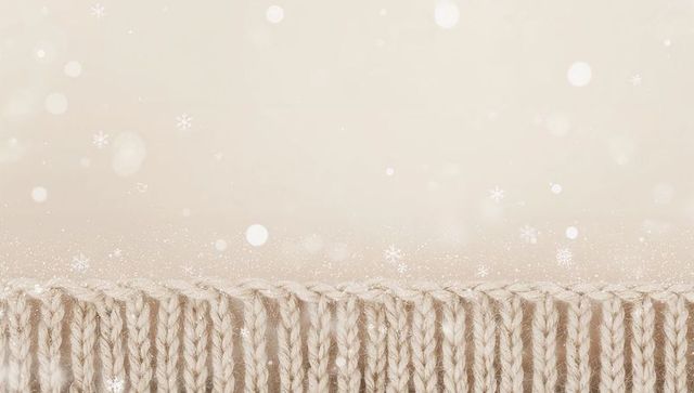 Beige knitted border with ribbed braided stitches and soft snow bokeh winter texture
