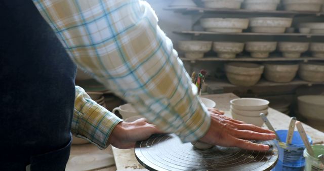 Potter shaping clay on spinning wheel in workshop - Download Free Stock Images Pikwizard.com