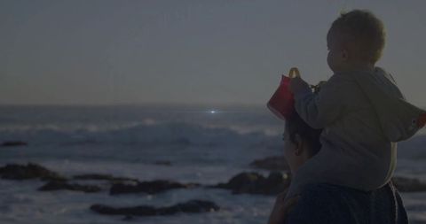 Mother and Child at Rocky Shoreline: Ocean Adventure and Family Bonding