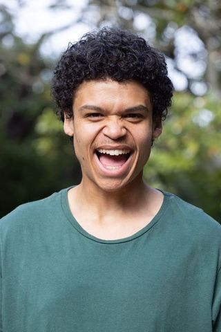 Joyful african american man laughing outdoors close-up natural candid energetic portrait