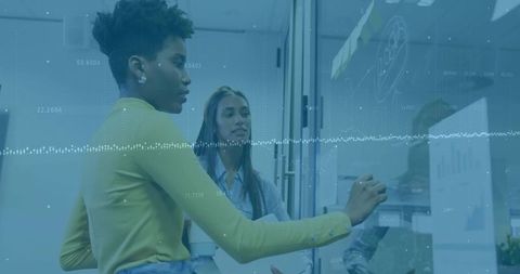 Women Collaborating on Glass Board with Data Charts and Brainstorming Session