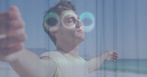 Young Man Embracing Nature and Technology on Sandy Beach