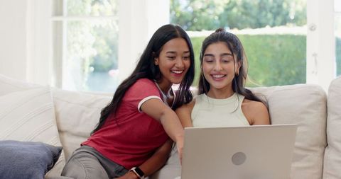 Diverse Female Friends using Laptop in Bright Living Room