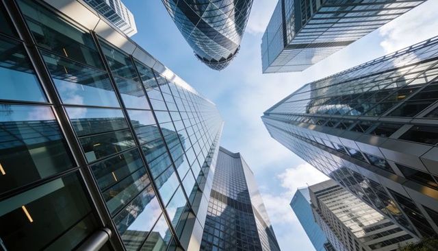 Glass skyscrapers rising in financial district with reflective facades and rounded tower