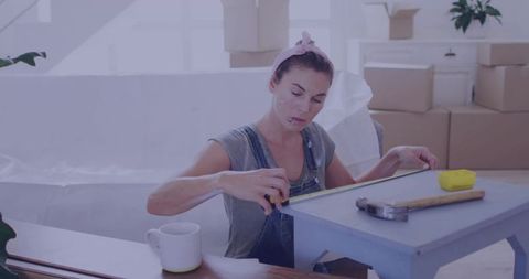 Woman measuring table in room undergoing renovation