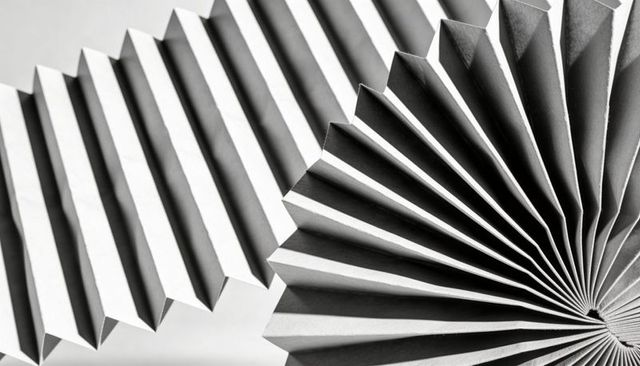 Monochrome accordion folds creating radial geometry and bold shadow contrast