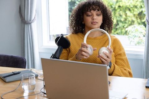 African american woman testing white headphones laptop microphone podcast recording