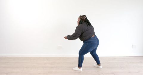 Energetic Woman Dancing Indoors in Casual Attire