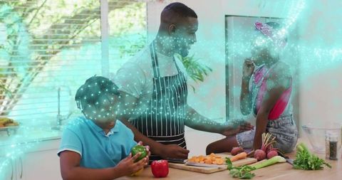 Father teaching children cooking on bright kitchen island with fresh vegetables and herbs