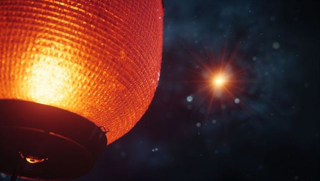 Illuminated Red Lantern in Night Sky with Star Flare