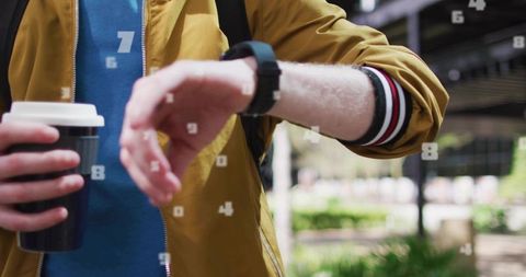 Commuter Checking Smartwatch While Holding Takeaway Coffee on Urban Transit Platform