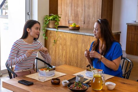 Asian Mother and Daughter Enjoying Salad Together at Home