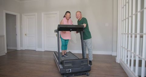 Senior Couple Enjoying Treadmill Exercise at Home Together