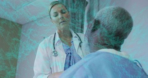 Female clinician examining seated patient during clinic consultation wearing stethoscope