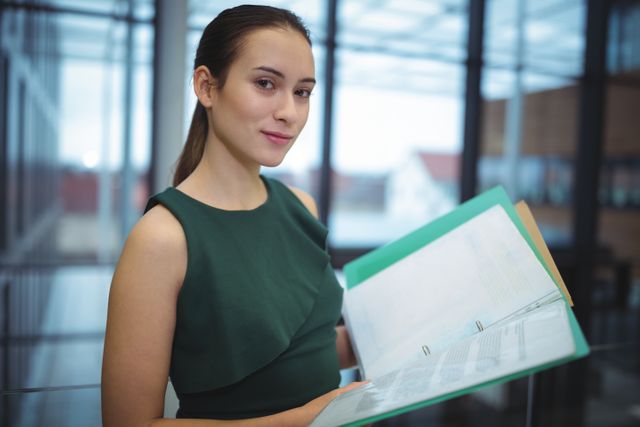 Portrait of businesswoman holding files at office