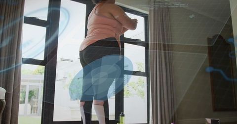 Woman Stretching by Glass Patio Doors in Bright Living Room Preparing for Home Workout