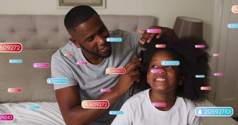 Father combing daughter's hair on bed with social media elements overlay