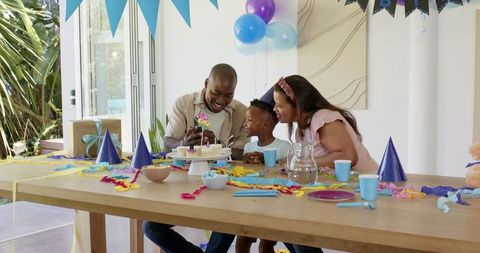 Happy Family Celebrating Child's Birthday with Cake and Laughter