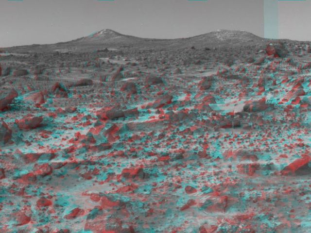 The two hills in the distance in this stereo image from NASA Mars Pathfinder have been dubbed the Twin Peaks. 3D glasses are necessary to identify surface detail.   