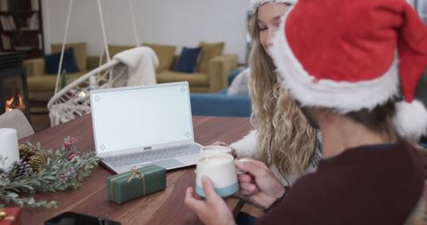 Couple in Santa Hats Celebrating Christmas with Laptop