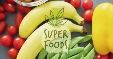 Colorful superfoods: healthy bananas, tomatoes, snap peas, and almonds overhead