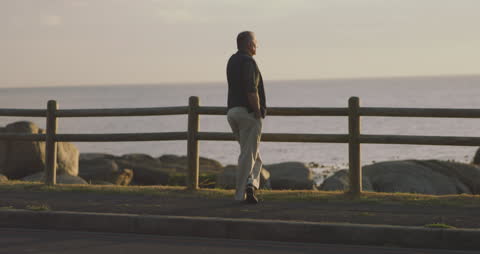 Senior Man Reflecting by Seaside at Dusk