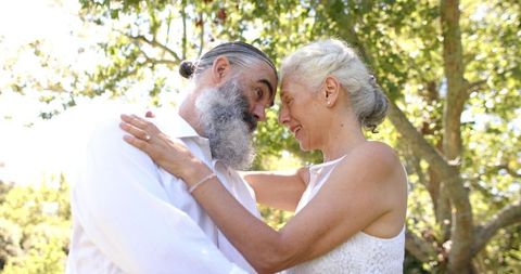 Joyful Senior Couple Embracing in Outdoor Wedding Celebration
