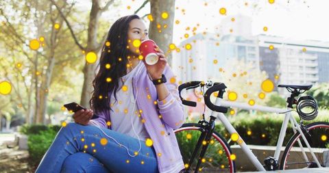 Woman Relaxing in Urban Park with Coffee and Bicycle