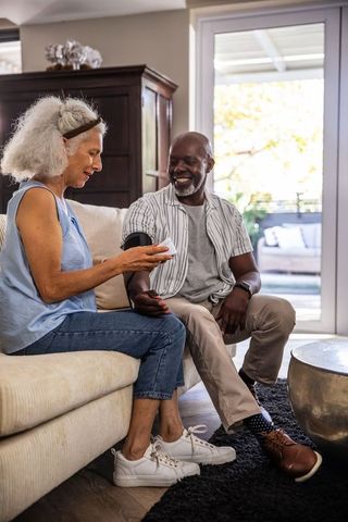 Diverse Senior Couple Monitoring Health with Digital Device at Home