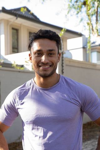 Cheerful man standing outdoor in suburban neighborhood