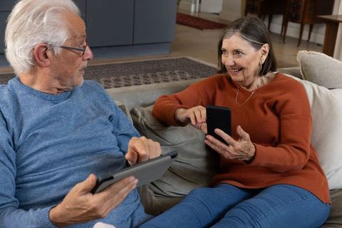 Senior Couple Enjoying Technology on Sofa