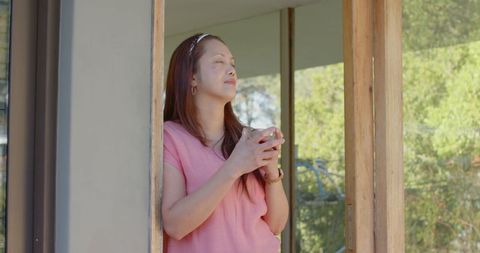 Relaxed Woman Enjoying Nature With Ceramic Mug in Doorway