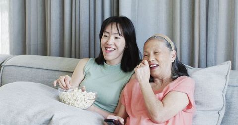 Grandmother and Granddaughter Relaxing With Popcorn