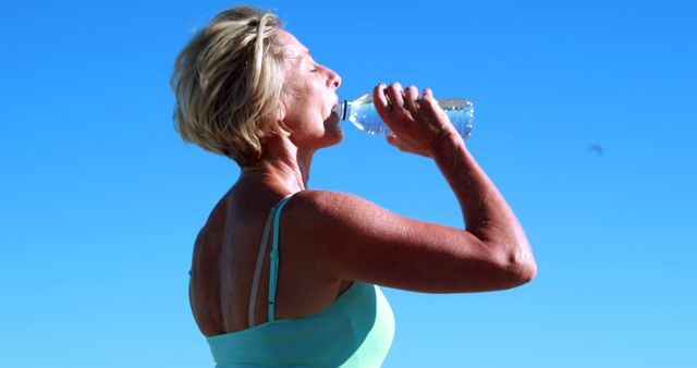 Senior Woman Drinking Water Outdoors Under Clear Blue Sky - Download Free Stock Images Pikwizard.com