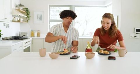 Diverse Couple Enjoying Breakfast with Pancakes in Modern Kitchen