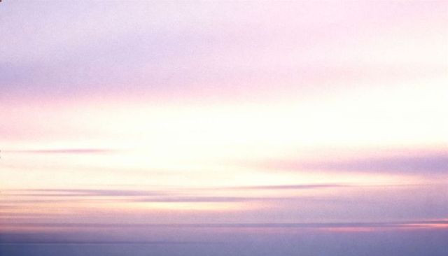 Pastel dawn over calm sea with layered clouds and minimalist horizon