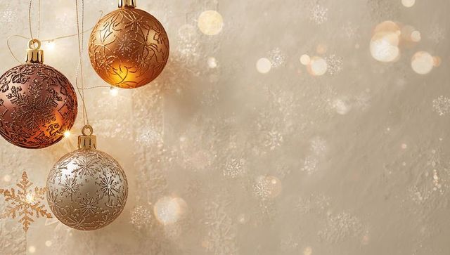 Hanging metallic christmas baubles trio with golden bokeh on warm beige backdrop
