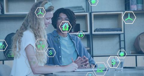 Young colleagues collaborating on sustainable business planning with green energy icons