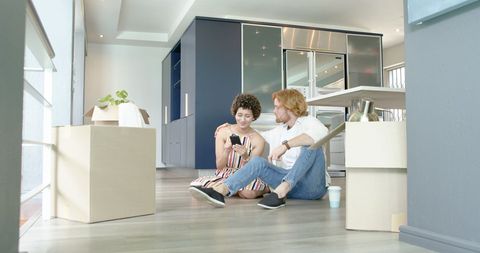 Happy Couple Embracing and Relaxing with Smartphone During Move