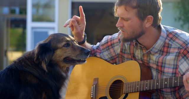 Man Playing Guitar and Training Dog Outdoors - Download Free Stock Images Pikwizard.com