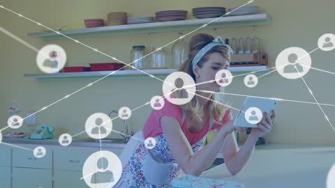 Woman in Kitchen Using Tablet with Digital Network Overlay