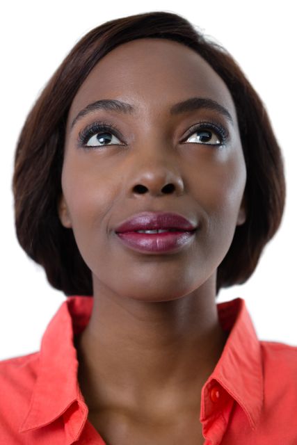 This image captures a close-up of a young woman looking upwards against a white background. Her expression is thoughtful and serene, making it ideal for use in advertisements, inspirational content, or articles focused on contemplation, confidence, and beauty. The clean background allows for easy integration into various designs and layouts.
