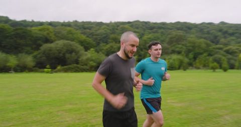 Two men jogging together for outdoor exercise in scenic park
